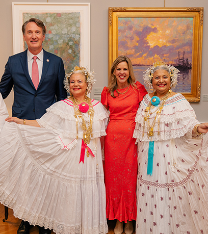 El Gobernador y la Primera Dama posan con dos mujeres vestidas con atuendos tradicionales panameños.