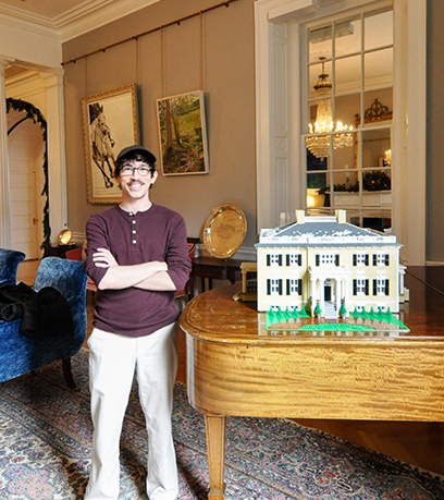 Benjamin Edlavitch de pie con su modelo LEGO de la Mansión Ejecutiva.