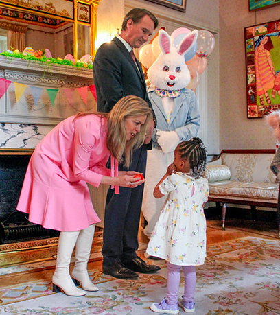 niña conociendo a la Primera Dama, el Gobernador y el Conejo de Pascua