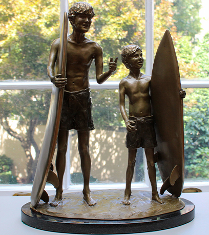 Una escultura de dos jóvenes surfistas